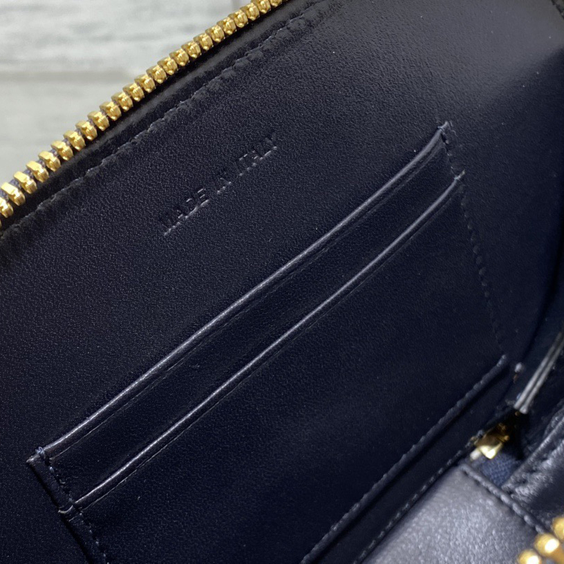 Doir Elliptical Camera Bag Features A Unique Letter Embossed Logo And Spacious Compartment Design. It Is Equipped With A Leather Top Handle And An Adjustable And Detachable Chain Shoulder Strap That Can Be Carried By Hand. The Shoulder Back Or Crossb