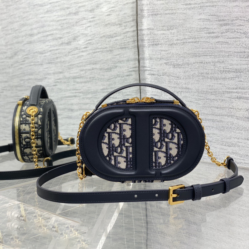 Doir Elliptical Camera Bag Features A Unique Letter Embossed Logo And Spacious Compartment Design. It Is Equipped With A Leather Top Handle And An Adjustable And Detachable Chain Shoulder Strap That Can Be Carried By Hand. The Shoulder Back Or Crossb