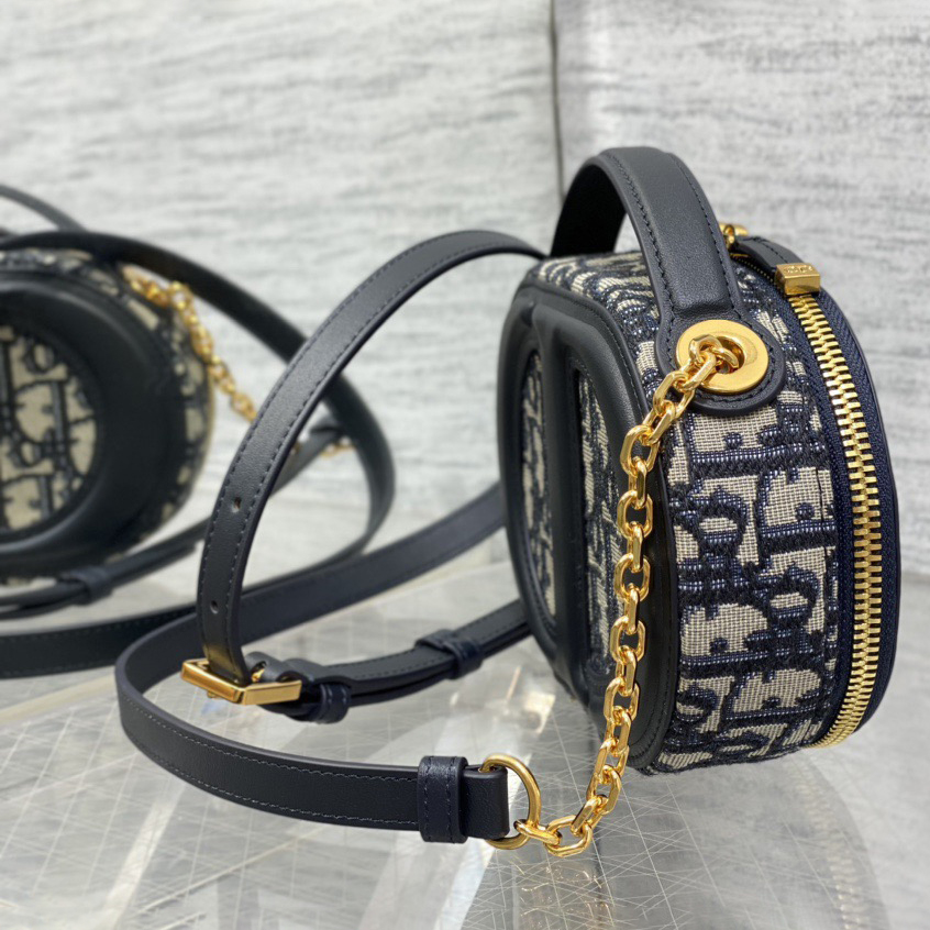 Doir Elliptical Camera Bag Features A Unique Letter Embossed Logo And Spacious Compartment Design. It Is Equipped With A Leather Top Handle And An Adjustable And Detachable Chain Shoulder Strap That Can Be Carried By Hand. The Shoulder Back Or Crossb