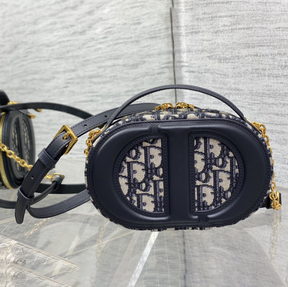 Doir Elliptical Camera Bag Features A Unique Letter Embossed Logo And Spacious Compartment Design. It Is Equipped With A Leather Top Handle And An Adjustable And Detachable Chain Shoulder Strap That Can Be Carried By Hand. The Shoulder Back Or Crossb